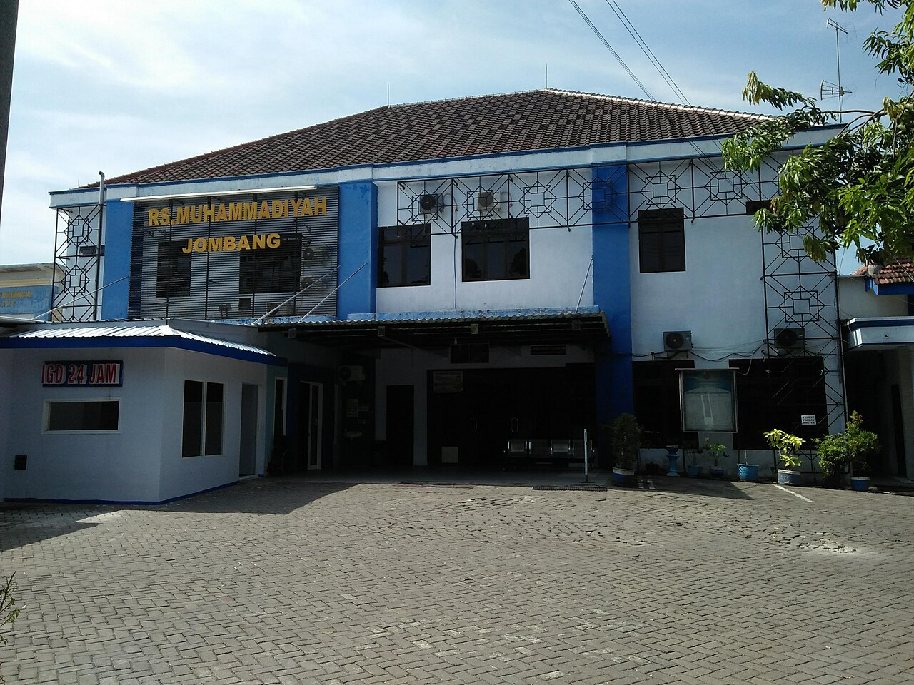 Gedung rumah sakit bertingkat dengan papan penunjuk arah
