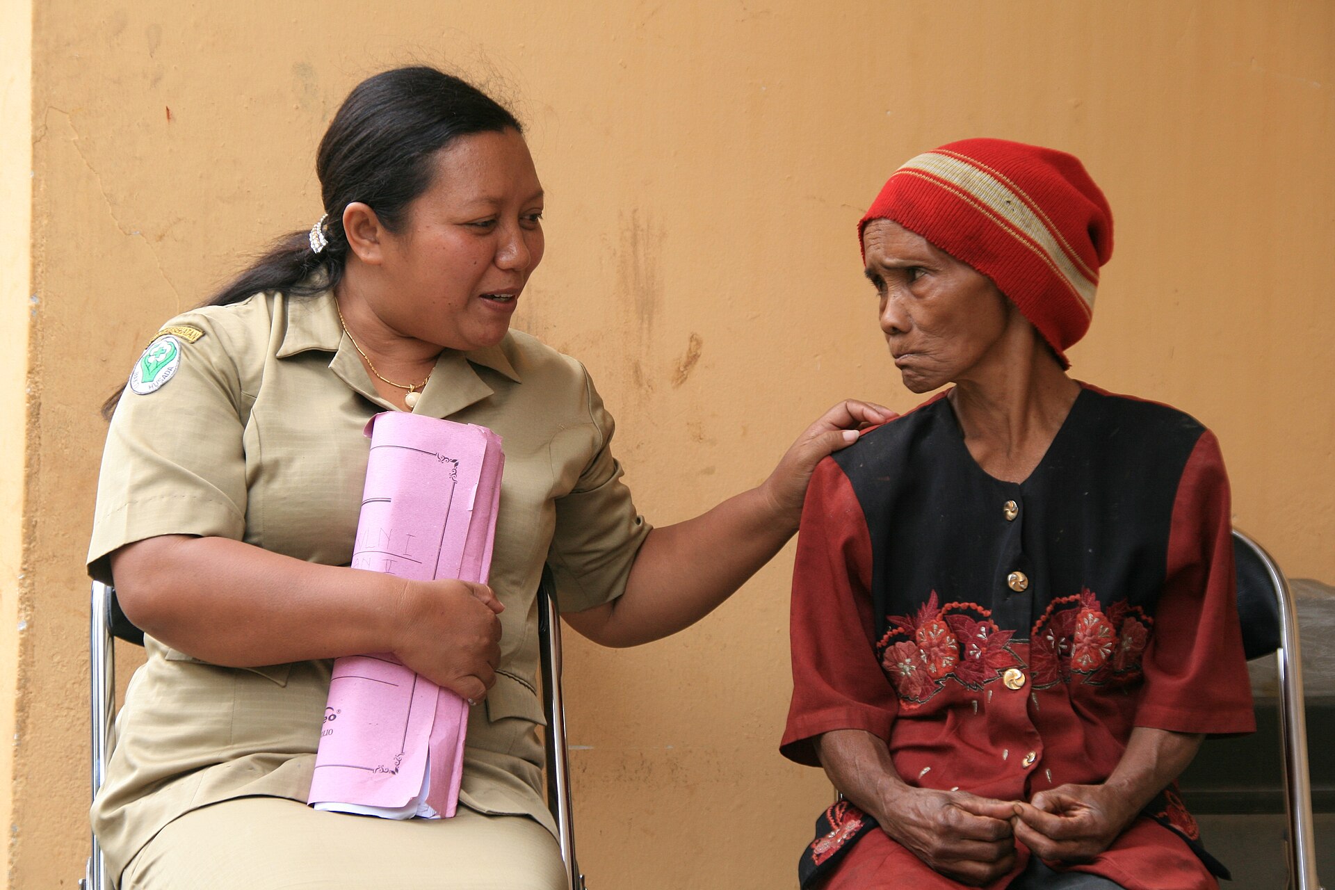 Petugas kesehatan berbincang dengan seorang warga di ruang layanan